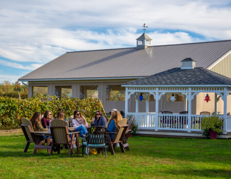 Friends tasting wine outdoors at Liberty Vineyards