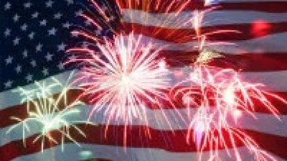 Fireworks exploding with an American flag in the backdrop.