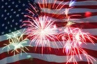Fireworks exploding with an American flag in the backdrop.