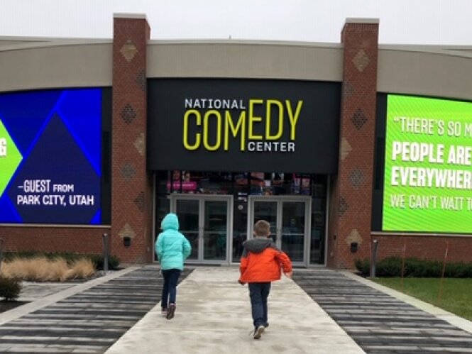 Two kids excited about touring the National Comedy Center, running