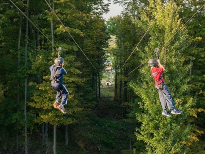 Two people on the zipline at Peek'n Peak Resort