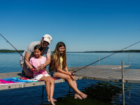 dad and kids fishing on dock