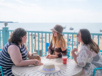 Women having drinks at Cabana Sam's with view of Sunset Bay Beach and Lake Erie web