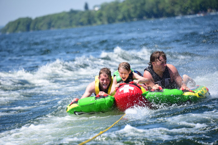 Three children tubing on Chautauqua Lake NY, laughing
