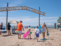 Family walking onto Sunset Bay Beach web